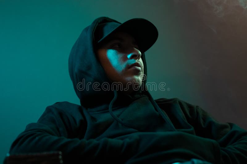 De jongelui koelt rapper die met zwart hoodie en GLB zijdelings kijken royalty-vrije stock foto De jongelui koelt rapper die met zwart hoodie en GLB zijdelings kijken royalty-vrije stock foto