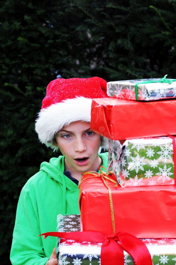 De jongen die Kerstmis bekijkt stelt voor stock fotografie De jongen die Kerstmis bekijkt stelt voor stock fotografie