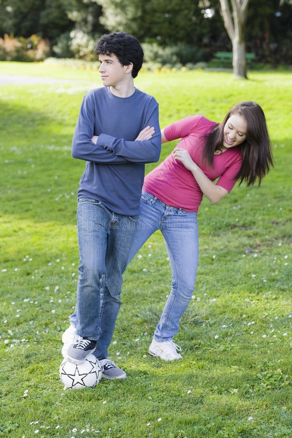 De Jongen en het Meisje van de tiener met de bal van het Voetbal stock afbeeldingen De Jongen en het Meisje van de tiener met de bal van het Voetbal stock afbeeldingen