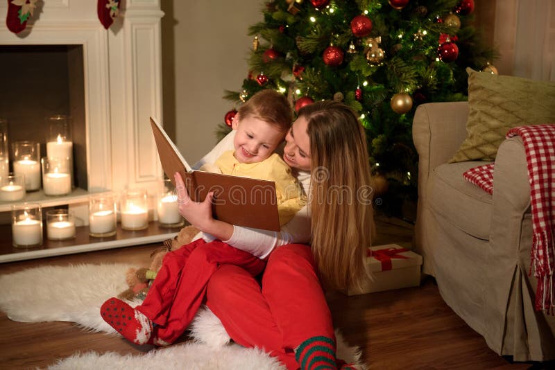 De jongen en zijn mamma lezen een boek samen lachend royalty-vrije stock foto's De jongen en zijn mamma lezen een boek samen lachend royalty-vrije stock foto's