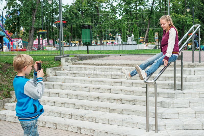 De jongen schiet meisje op smartphone stock foto's De jongen schiet meisje op smartphone stock foto's
