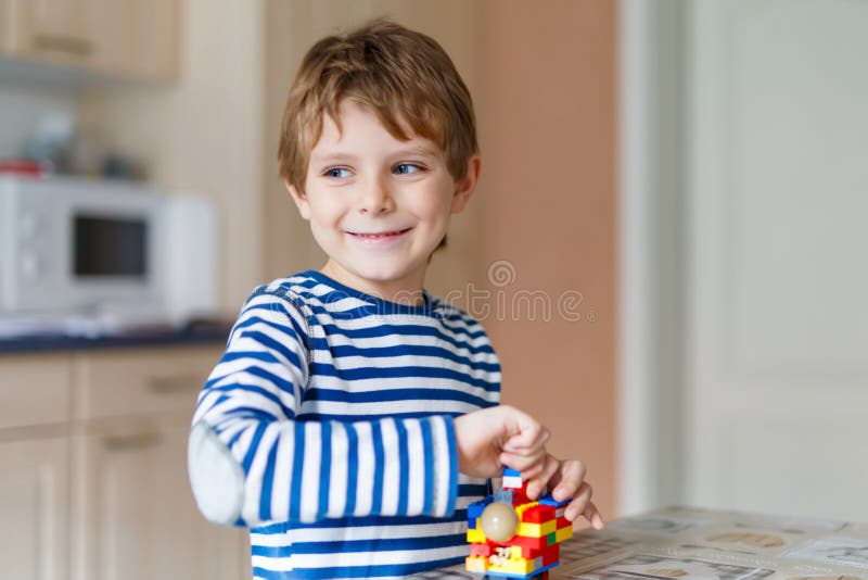 De jongen van het schooljonge geitje het spelen met veel klein kleurrijk plastic blok stock fotografie De jongen van het schooljonge geitje het spelen met veel klein kleurrijk plastic blok stock fotografie