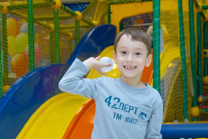 De jongen werpt een plastic bal in een droge pool van een het vermaakcentrum van kinderen Cheboksary, Rusland, 02/12/2018 royalty-vrije stock afbeelding De jongen werpt een plastic bal in een droge pool van een het vermaakcentrum van kinderen Cheboksary, Rusland, 02/12/2018 royalty-vrije stock afbeelding