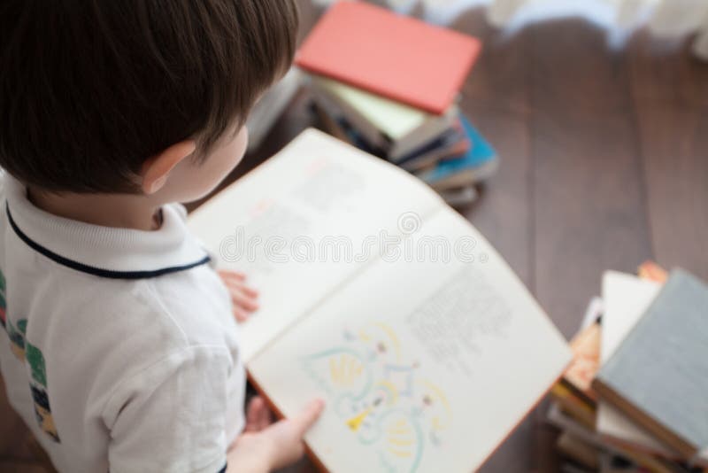 De jongens` s rug en een open boek stock afbeelding De jongens` s rug en een open boek stock afbeelding