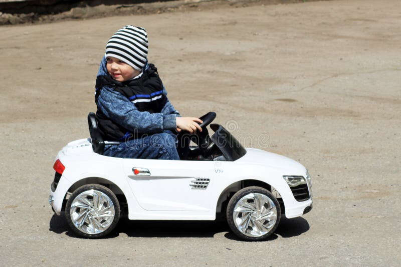 2 de junho de 2018 Izhevsk, Rússia Rapaz pequeno que conduz o carro do brinquedo no campo de jogos do tráfego fotografia de stock 2 de junho de 2018 Izhevsk, Rússia Rapaz pequeno que conduz o carro do brinquedo no campo de jogos do tráfego fotografia de stock