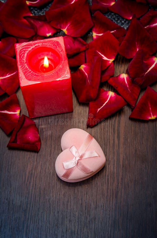 De kaars, rood bloemblaadje nam met giftvakje toe op lijst Het concept van de valentijnskaart royalty-vrije stock afbeelding De kaars, rood bloemblaadje nam met giftvakje toe op lijst Het concept van de valentijnskaart royalty-vrije stock afbeelding