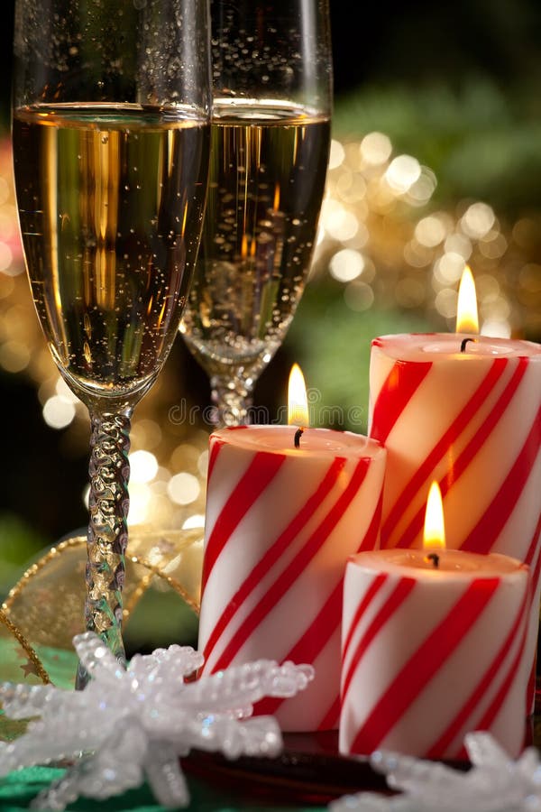 Closeup of peppermint candles, flutes of champaine champagne and Christmas tree with lights out of focus in background. Shallow DOF. Closeup of peppermint candles, flutes of champaine champagne and Christmas tree with lights out of focus in background. Shallow DOF.