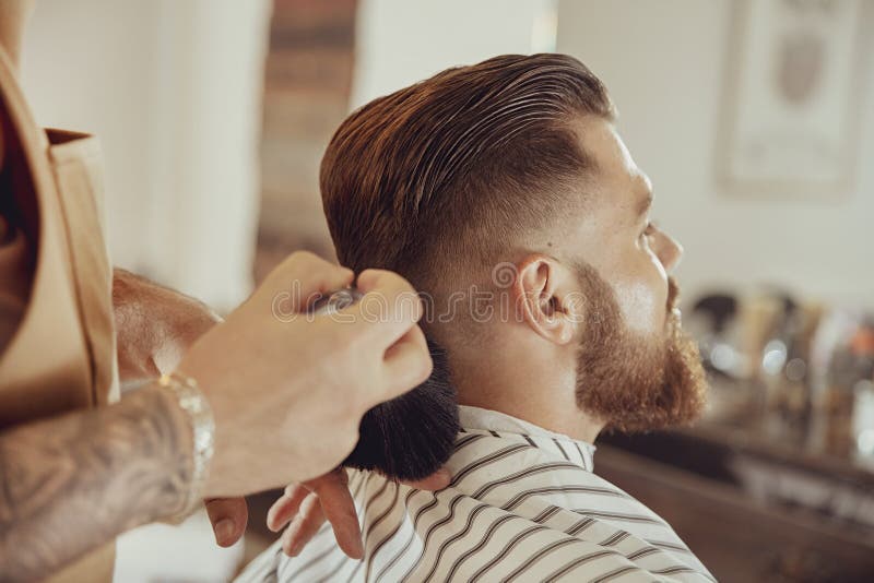 De kapper schudt weg haar van de cliënt` s hals stock afbeeldingen De kapper schudt weg haar van de cliënt` s hals stock afbeeldingen