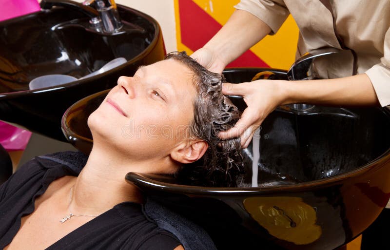 De kappers overhandigen was het haar van de vrouwelijke klant in salon stock foto De kappers overhandigen was het haar van de vrouwelijke klant in salon stock foto