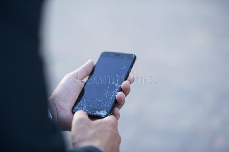 De kerel houdt een smartphone met het gebroken scherm in zijn hand royalty-vrije stock afbeeldingen De kerel houdt een smartphone met het gebroken scherm in zijn hand royalty-vrije stock afbeeldingen
