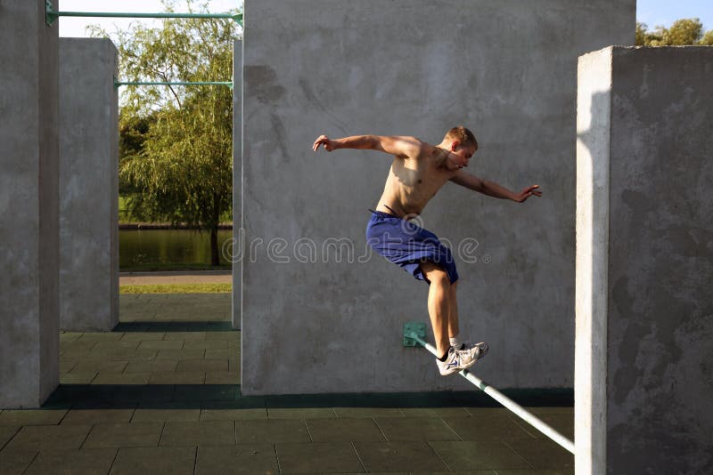 De kerel voert een sprong op de plaats voor het praktizeren uit parkour stock foto's De kerel voert een sprong op de plaats voor het praktizeren uit parkour stock foto's