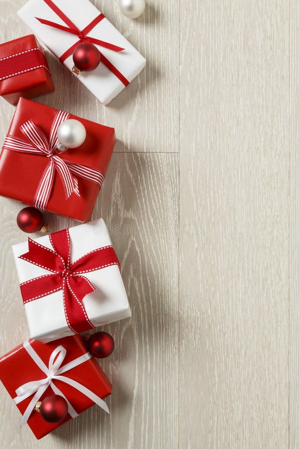 De Kerstmisgiften stelt op rustieke houten achtergrond voor Eenvoudige, rode en witte feestelijke de vakantiegrens van giftdozen