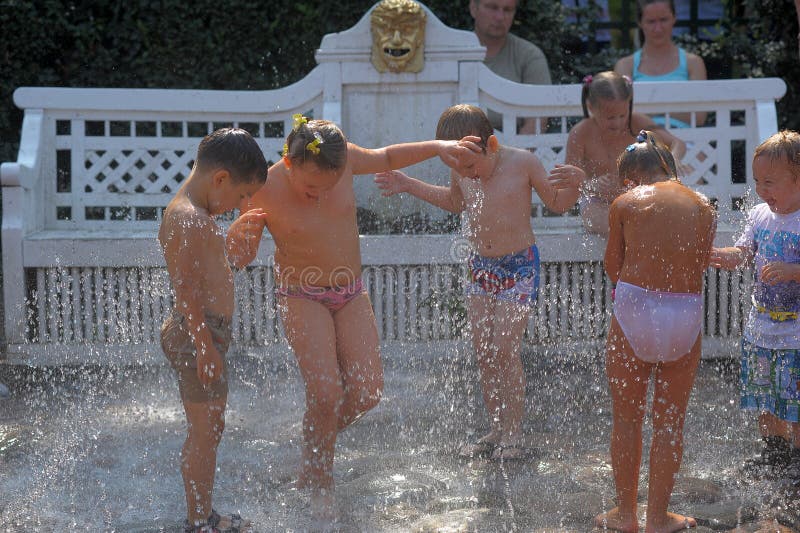 De kinderen stoeien in de fonteinstralen stock afbeelding De kinderen stoeien in de fonteinstralen stock afbeelding