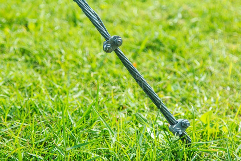 De Klem van de staalkabelslinger op gras royalty-vrije stock foto De Klem van de staalkabelslinger op gras royalty-vrije stock foto