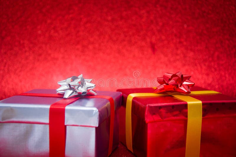 De kleurrijke Giftdozen op rood schitteren achtergrond stock foto's