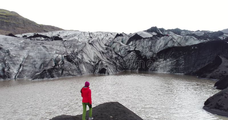 De klimaatverandering en de opwarming van de persoon die op de gletsjer op IJsland lopen
