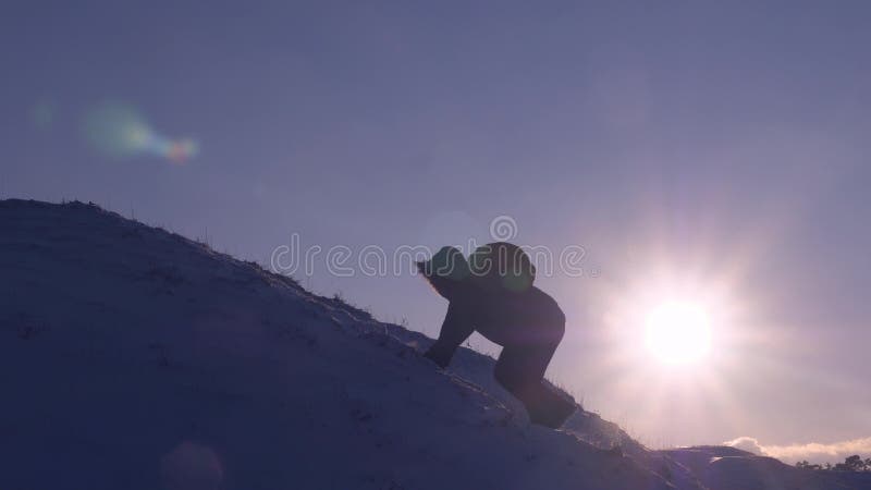 De klimmer beklimt sneeuwberg in stralen van heldere zon De toerist maakt klim tot bovenkant op achtergrond van mooie hemel Mens stock foto De klimmer beklimt sneeuwberg in stralen van heldere zon De toerist maakt klim tot bovenkant op achtergrond van mooie hemel Mens stock foto