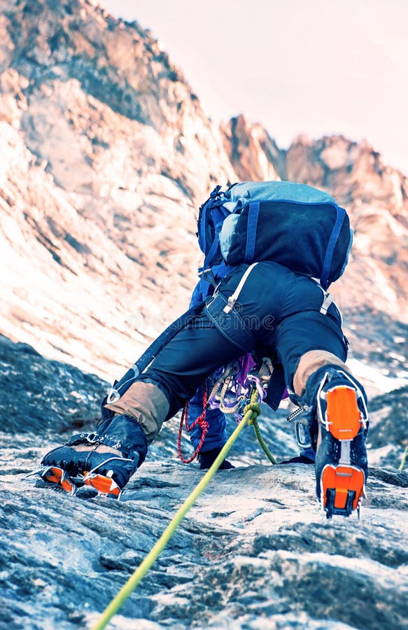 De klimmer bereikt de top van bergpiek Het beklimmen en mounta stock foto De klimmer bereikt de top van bergpiek Het beklimmen en mounta stock foto