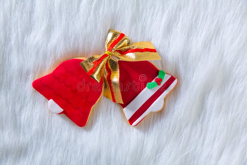 De klokvorm en lint van Kerstmiskoekjes rode op wit bont stock foto's De klokvorm en lint van Kerstmiskoekjes rode op wit bont stock foto's
