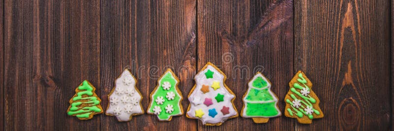 De koekjes van de Kerstmispeperkoek in de vorm van Kerstbomen op een bruine houten lijst De ruimte van het exemplaar stock fotografie De koekjes van de Kerstmispeperkoek in de vorm van Kerstbomen op een bruine houten lijst De ruimte van het exemplaar stock fotografie