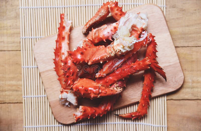 Alaskan King Crab Legs cooked seafood on wooden cutting board background / red crab hokkaido. Alaskan King Crab Legs cooked seafood on wooden cutting board background / red crab hokkaido