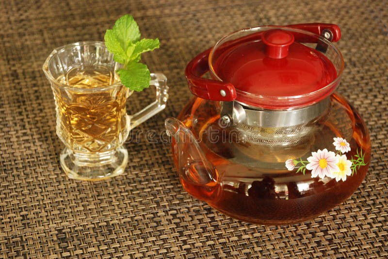 De kop thee met groen muntblad op de lijst diende te drinken stock foto De kop thee met groen muntblad op de lijst diende te drinken stock foto
