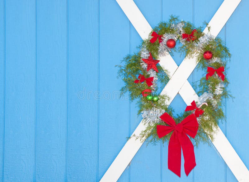 De kroon van Kerstmis het hangen op een blauwe deur stock foto's De kroon van Kerstmis het hangen op een blauwe deur stock foto's