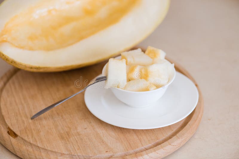De kubussen van de Cuttedmeloen op keuken scherpe raad royalty-vrije stock foto De kubussen van de Cuttedmeloen op keuken scherpe raad royalty-vrije stock foto
