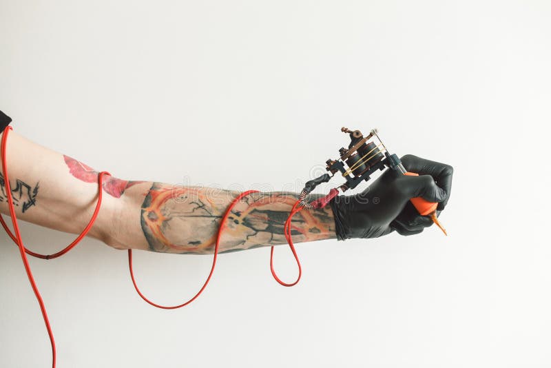 De kunstenaar van de handtatoegering met de tatoegeringsmachine