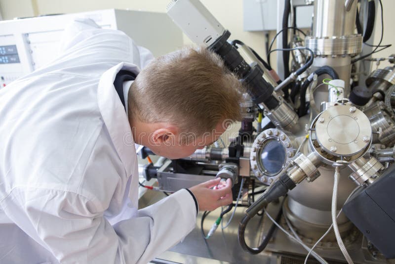 De laboratoriumspecialist onderzoekt de verkregen gegevens over een speciaal apparaat om steekproeven te analyseren stock afbeeldingen De laboratoriumspecialist onderzoekt de verkregen gegevens over een speciaal apparaat om steekproeven te analyseren stock afbeeldingen
