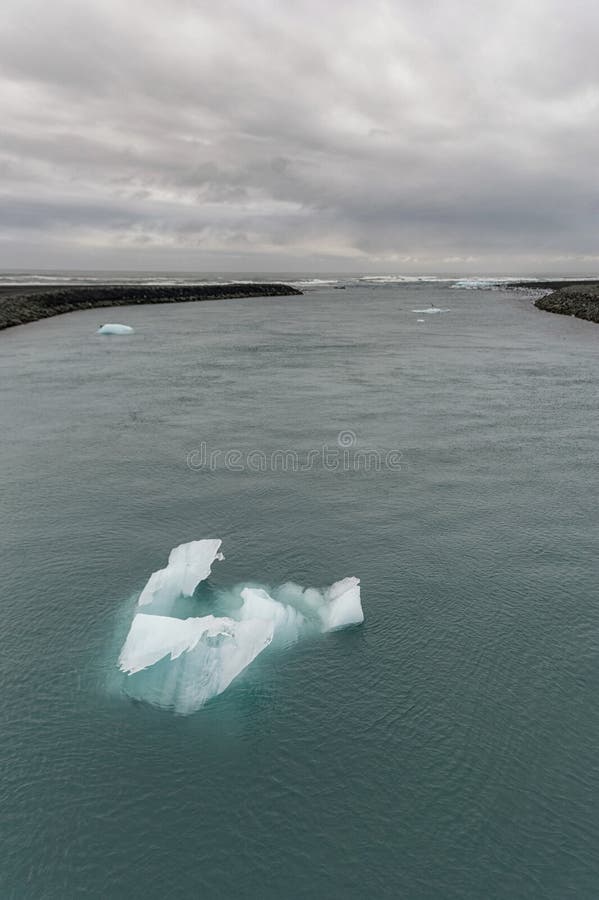 De lagune van de Jokulsarlongletsjer in IJsland Bewolkte Hemel, Oceaan en Ijsberg stock afbeelding De lagune van de Jokulsarlongletsjer in IJsland Bewolkte Hemel, Oceaan en Ijsberg stock afbeelding