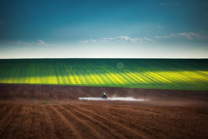 De landbouw van tractor die en op gebied ploegt bespuit royalty-vrije stock foto's De landbouw van tractor die en op gebied ploegt bespuit royalty-vrije stock foto's