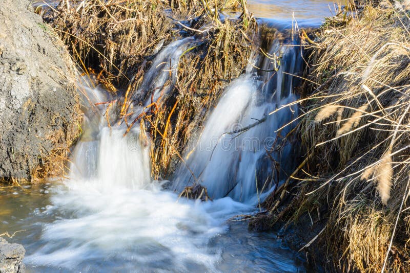 De langverwachte stroom van de lentekreken over ravijnen en heuvels op een zonnige dag Waterstroomversnelling en watervallen van royalty-vrije stock foto's De langverwachte stroom van de lentekreken over ravijnen en heuvels op een zonnige dag Waterstroomversnelling en watervallen van royalty-vrije stock foto's