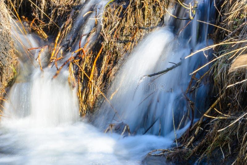 De langverwachte stroom van de lentekreken over ravijnen en heuvels op een zonnige dag Waterstroomversnelling en watervallen van stock afbeelding De langverwachte stroom van de lentekreken over ravijnen en heuvels op een zonnige dag Waterstroomversnelling en watervallen van stock afbeelding