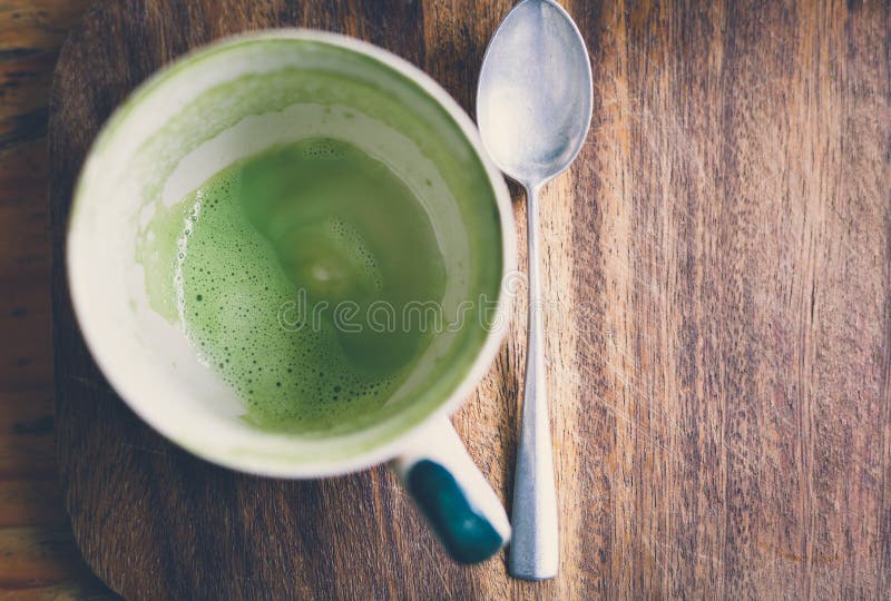 De lege kop van de matcha latte groene thee op een houten raad royalty-vrije stock foto's De lege kop van de matcha latte groene thee op een houten raad royalty-vrije stock foto's