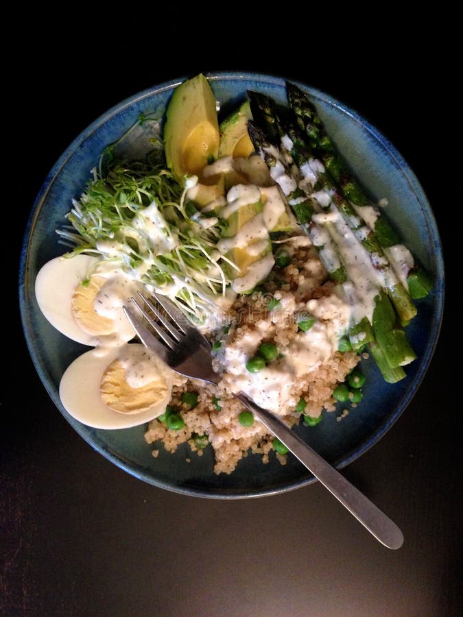 De lentemaaltijd: quinoa, avocado, asperge, ei, erwten, erwtenspruiten stock afbeelding De lentemaaltijd: quinoa, avocado, asperge, ei, erwten, erwtenspruiten stock afbeelding