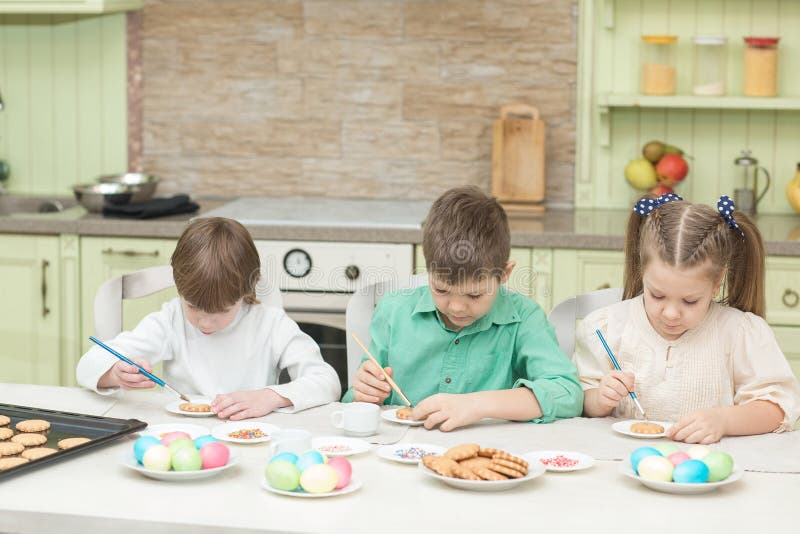 De leuke kinderen verfraaien koekjes bij een lijst in de huiskeuken