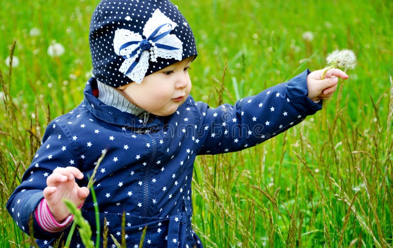 De leuke paardebloem van het babymeisje whith royalty-vrije stock afbeelding De leuke paardebloem van het babymeisje whith royalty-vrije stock afbeelding