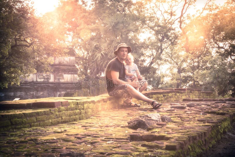 De levensstijlportret van de familiereis van mensenreiziger met kinddochter het rusten samen op ruïnes bij zonsondergang tijdens stock foto's De levensstijlportret van de familiereis van mensenreiziger met kinddochter het rusten samen op ruïnes bij zonsondergang tijdens stock foto's