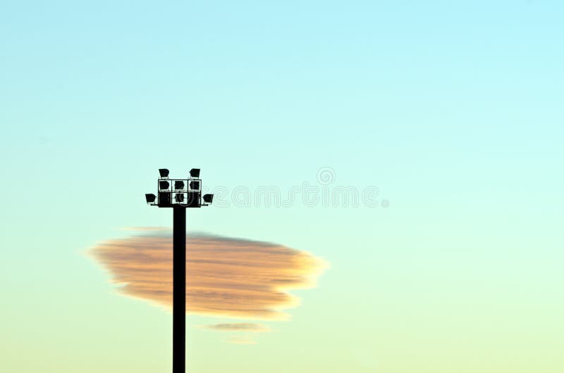 De lichtensilhouet van het stadion en zonsondergangwolk stock afbeelding De lichtensilhouet van het stadion en zonsondergangwolk stock afbeelding