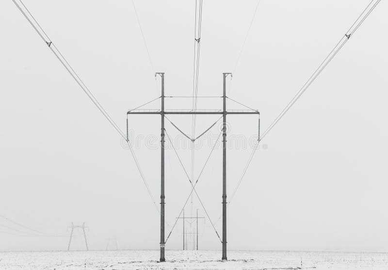 De lijnen van de hallo-voltage stroom in een winters mistig landschap, zwart-witte foto stock foto's De lijnen van de hallo-voltage stroom in een winters mistig landschap, zwart-witte foto stock foto's
