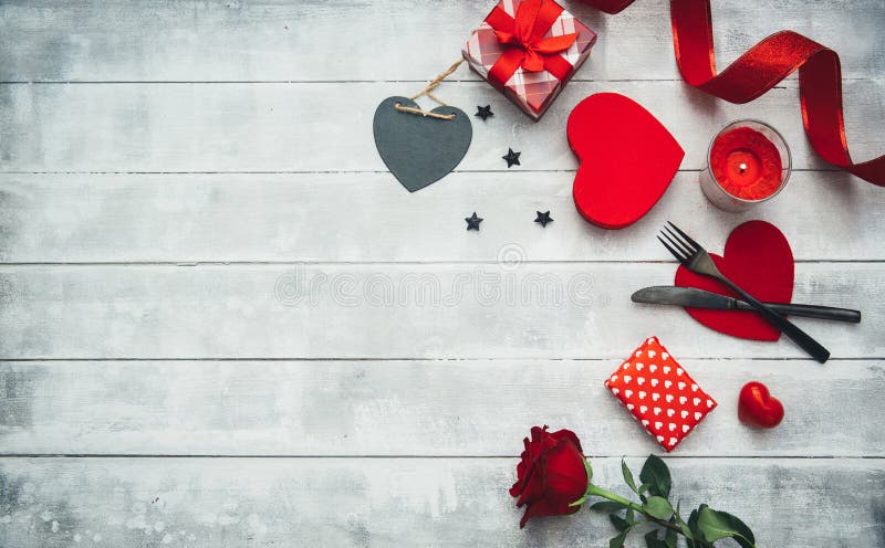 De lijst die van de valentijnskaartendag met vork, mes, rode harten, lint en rozen plaatsen royalty-vrije stock foto's De lijst die van de valentijnskaartendag met vork, mes, rode harten, lint en rozen plaatsen royalty-vrije stock foto's