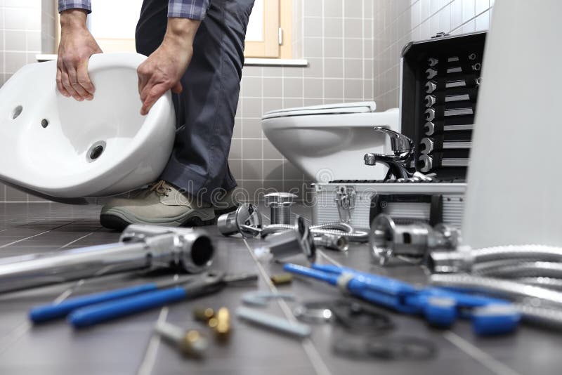 De loodgieter aan het werk in een badkamers, de dienst van de loodgieterswerkreparatie, assembleert royalty-vrije stock afbeeldingen De loodgieter aan het werk in een badkamers, de dienst van de loodgieterswerkreparatie, assembleert royalty-vrije stock afbeeldingen