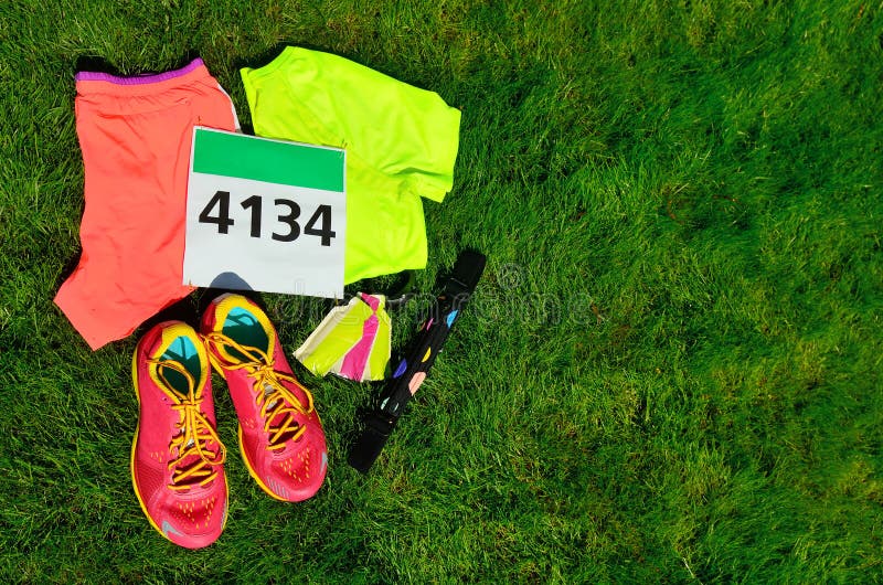 De loopschoenen, het de slabaantal van het marathonras, het agententoestel en de energie gelatineren op grasachtergrond, sport, f royalty-vrije stock fotografie De loopschoenen, het de slabaantal van het marathonras, het agententoestel en de energie gelatineren op grasachtergrond, sport, f royalty-vrije stock fotografie