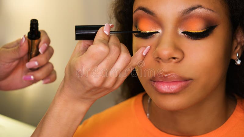 De make-upkunstenaar past make-up op gezicht van meisje toe stock afbeelding De make-upkunstenaar past make-up op gezicht van meisje toe stock afbeelding