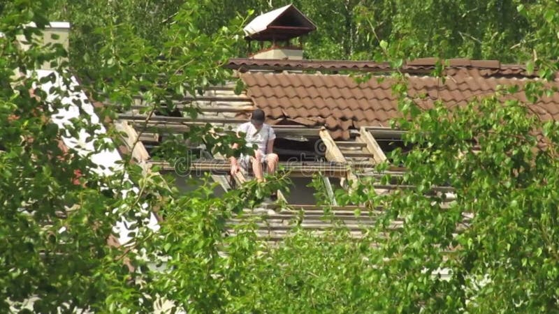 De man kruipt op het dak van een verlaten gebouw.