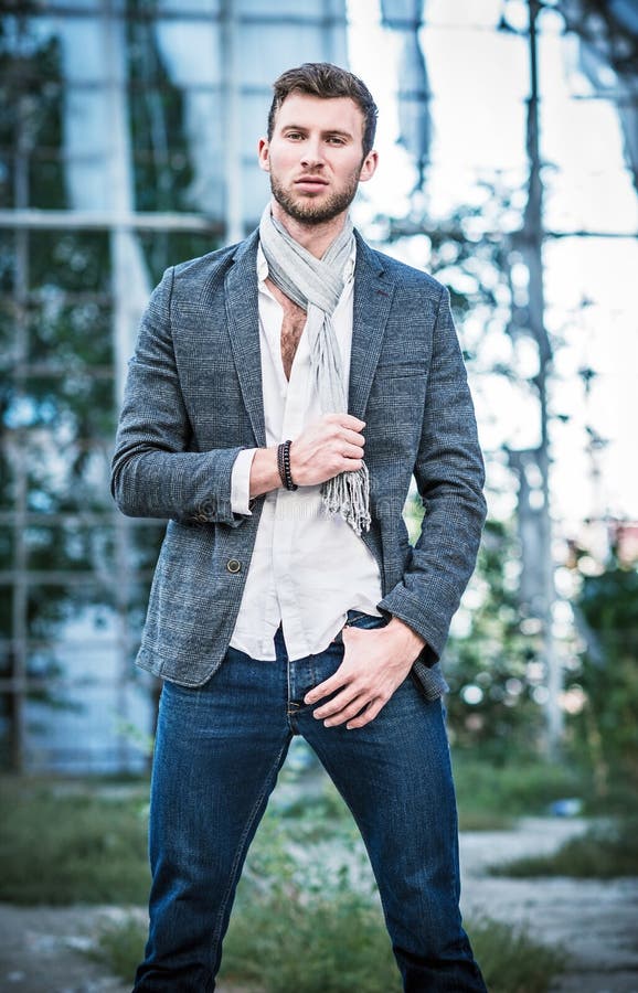 De manier schoot: portret van de knappe jonge mens die jeans, overhemd, jasje en sjaal dragen royalty-vrije stock afbeeldingen De manier schoot: portret van de knappe jonge mens die jeans, overhemd, jasje en sjaal dragen royalty-vrije stock afbeeldingen
