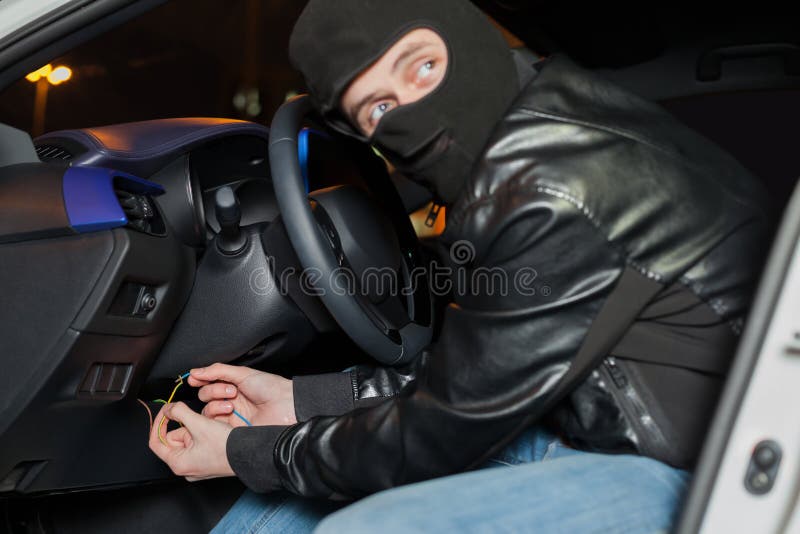 De mannelijke autodief breekt de ontstekingsschakelaar stock foto De mannelijke autodief breekt de ontstekingsschakelaar stock foto