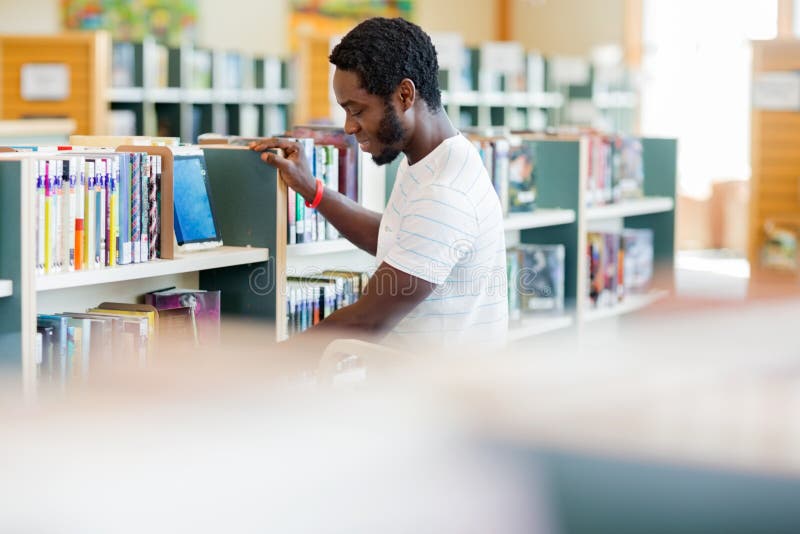 De mannelijke Boekhandel van Bibliothecarisarranging books in royalty-vrije stock afbeeldingen De mannelijke Boekhandel van Bibliothecarisarranging books in royalty-vrije stock afbeeldingen