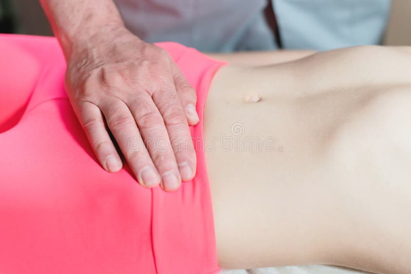 De mannelijke hand diepgewortelde therapeutmasseur behandelt een jonge vrouwelijke pati?nt Het externe verwarmen van de baarmoede stock foto De mannelijke hand diepgewortelde therapeutmasseur behandelt een jonge vrouwelijke pati?nt Het externe verwarmen van de baarmoede stock foto